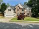Charming two-story home featuring stone and shingle siding, well-manicured lawn, and attached two-car garage at 1782 Telfair Chase Way, Lawrenceville, GA 30043