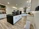 Spacious kitchen features an oversized island, stainless appliances, light wood floors, and white cabinetry at 1782 Telfair Chase Way, Lawrenceville, GA 30043