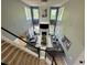 View from stairs overlooking living room with fireplace, large windows, and sectional at 1782 Telfair Chase Way, Lawrenceville, GA 30043