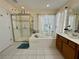 Main bathroom boasts a separate shower and a tiled tub, with bright natural light at 1782 Telfair Chase Way, Lawrenceville, GA 30043
