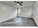 Spacious bedroom with a ceiling fan and sleek, dark gray wood flooring at 2211 Rocky Mill Dr, Lawrenceville, GA 30044