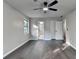 A bedroom with gray wood flooring, a ceiling fan and doors to the bathroom and hallway at 2211 Rocky Mill Dr, Lawrenceville, GA 30044
