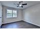 Bright bedroom featuring gray walls, dark wood-look floors, a window, and a ceiling fan at 2211 Rocky Mill Dr, Lawrenceville, GA 30044