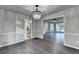 Open dining area featuring hardwood floors, chair railing, and a view into the modern kitchen at 2211 Rocky Mill Dr, Lawrenceville, GA 30044