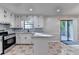 Open concept kitchen with white cabinets, gray backsplash, and stainless steel appliances at 2211 Rocky Mill Dr, Lawrenceville, GA 30044