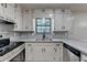 Well-lit kitchen featuring white cabinets, granite countertops, and stainless steel appliances at 2211 Rocky Mill Dr, Lawrenceville, GA 30044