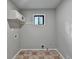 Neutral laundry room with a window, upper cabinet, and hookups for the washer and dryer at 2211 Rocky Mill Dr, Lawrenceville, GA 30044