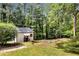 Backyard featuring a quaint shed surrounded by mature trees and greenery at 30 Dewey Se Ln, Marietta, GA 30060
