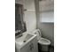 Bright bathroom featuring a vanity with a sink, a wood-framed mirror, and a toilet near a window at 735 Brookwood Dr, Forest Park, GA 30297