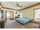 Large main bedroom with glass doors leading to sunroom, ceiling fan and carpeted floors at 9959 Point View Dr, Jonesboro, GA 30238