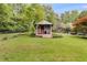 Fenced backyard featuring a small building with landscaped walkway among mature trees at 385 Vineyard Nw Dr, Marietta, GA 30064