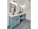 A bathroom has double sinks, vanity with blue cabinets, and modern lighting at 1075 Litchfield Sw Way, Marietta, GA 30060