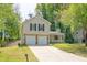 Inviting exterior showcasing a well-maintained lawn, covered porch, and convenient two-car garage at 1147 Williamsburg Ln, Norcross, GA 30093