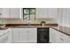 Efficient kitchen featuring stone countertops, white cabinets, and a stainless steel dishwasher at 1147 Williamsburg Ln, Norcross, GA 30093