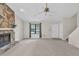 Comfortable living area with stone fireplace, neutral carpeting, and entry to the staircase at 1147 Williamsburg Ln, Norcross, GA 30093