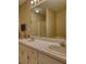Bathroom featuring dual sinks with vanity and large mirror, complemented by neutral wallpaper at 205 Summer Walk Dr, Covington, GA 30016