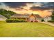 Charming one-story home with well-manicured lawn and a two-car garage with a stunning sunset at 205 Summer Walk Dr, Covington, GA 30016