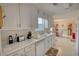 Spacious kitchen with white cabinets, stainless steel sink and a view of the dining area at 205 Summer Walk Dr, Covington, GA 30016