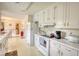 Open kitchen with white cabinets, laminate countertops and an adjacent eating area at 205 Summer Walk Dr, Covington, GA 30016