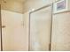 Shower with glass door and white tile, complemented by neutral patterned wallpaper at 205 Summer Walk Dr, Covington, GA 30016