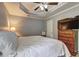 Bedroom with tray ceiling, ceiling fan, dresser with TV, and window at 3452 Chesterfield Ct, Snellville, GA 30039
