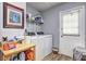 Functional laundry room with modern washer and dryer, organization shelf, and exterior door at 3452 Chesterfield Ct, Snellville, GA 30039