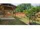 Covered patio and landscaped backyard featuring lush green grass, tiered landscaping, and a wooden fence at 965 Mulberry Bay Dr, Dacula, GA 30019