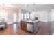 Open-concept kitchen boasts granite countertops and stainless steel appliances with hardwood flooring and elegant lighting at 965 Mulberry Bay Dr, Dacula, GA 30019