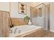 Bathroom featuring a soaking tub with tiled surround and glass enclosed shower at 1242 Morton Trce Se, Atlanta, GA 30316