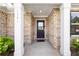 Close-up of the front door entrance featuring white columns and brick surround at 1341 Midnight Ride Ct, Hampton, GA 30228