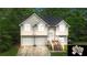 Charming two-story home with two-car garage, landscaped yard, and inviting front entrance, nestled among mature trees at 59 Abbotsford Dr, Villa Rica, GA 30180