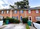 Two-story brick townhome showcasing colorful shutters, mature landscaping, and convenient parking at 1038 Westfield Se Trce, Smyrna, GA 30082