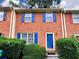 Charming brick townhome featuring a bright blue front door and lush green landscaping at 1038 Westfield Se Trce, Smyrna, GA 30082