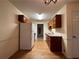 Efficient kitchen with wood cabinets, white appliances, and a door to an adjacent room at 1038 Westfield Se Trce, Smyrna, GA 30082