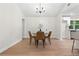 Dining area adjacent to the kitchen with modern lighting and seating for four, showcasing wood floors at 1490 Diplomat Dr, Riverdale, GA 30296