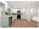 Modern kitchen with stainless steel appliances, quartz countertops, white cabinetry, and wood floors at 1490 Diplomat Dr, Riverdale, GA 30296