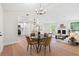 Open-concept living area with dining and kitchen featuring wood floors, fireplace, and modern lighting at 1490 Diplomat Dr, Riverdale, GA 30296
