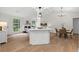 Open-concept living area featuring wood floors, dining area, and kitchen island with bar seating at 1490 Diplomat Dr, Riverdale, GA 30296