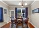 Charming dining area with a wooden table, chairs, natural light, and decor, set near a back door at 2376 Roberts View Trail, Buford, GA 30519