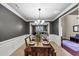 Formal dining room with wainscotting, grey walls, modern chandelier and is set for a lovely meal at 2376 Roberts View Trail, Buford, GA 30519