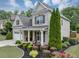 Well-maintained exterior with manicured landscaping, green lawn, and a charming covered porch area at 2376 Roberts View Trail, Buford, GA 30519