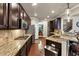 Modern kitchen with stainless appliances, granite counters, tile backsplash, breakfast bar, and adjacent dining area at 2376 Roberts View Trail, Buford, GA 30519
