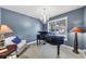 Cozy living room featuring a grand piano, comfortable seating, and natural light from a window at 2376 Roberts View Trail, Buford, GA 30519