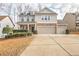 Charming two-story home with stone accents, a well-manicured lawn, and a spacious driveway at 5195 Belmore Manor Ct, Suwanee, GA 30024