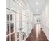 Elegant hallway features dark hardwood floors, white wainscoting, and glass french doors at 5195 Belmore Manor Ct, Suwanee, GA 30024