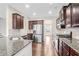 Modern kitchen with granite countertops, stainless steel appliances, and dark wood cabinets at 5195 Belmore Manor Ct, Suwanee, GA 30024