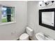 A charming powder room features a modern toilet and sink with a decorative framed mirror and natural lighting at 9979 Bridgewater Pointe, Villa Rica, GA 30180
