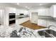 Spacious kitchen with granite counters, stainless steel appliances, and white cabinetry at 9979 Bridgewater Pointe, Villa Rica, GA 30180
