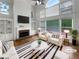 Bright, staged living room with vaulted ceilings, large windows, fireplace, and hardwood floors at 9979 Bridgewater Pointe, Villa Rica, GA 30180