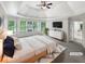 Staged main bedroom with a tray ceiling, lots of natural light, and ensuite bathroom at 9979 Bridgewater Pointe, Villa Rica, GA 30180